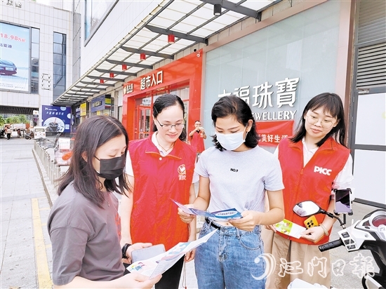 恩平人保財險工作人員向群眾派發(fā)宣傳折頁，普及金融知識。