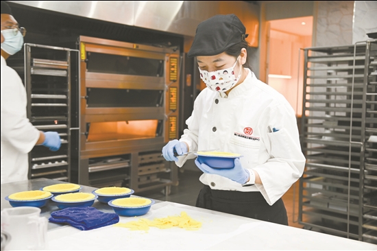 近年來，美心集團等港資企業(yè)選擇在江門投資。圖為美心集團員工在制作糕點美食。