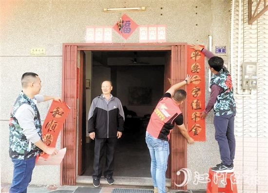 志愿者到退役軍人家中貼對聯(lián)、送祝福。
