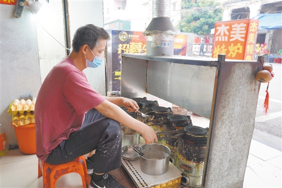 店鋪老板正在烤制爐底糍。