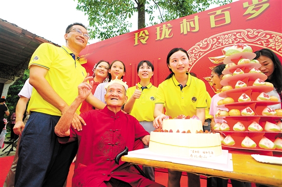 董淑猛（前排左一）、徐娜（豎大拇指者）等人為梁如旺老人慶祝百歲生日。
