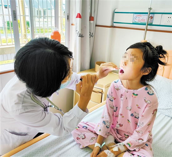 兒科醫(yī)生為手足口病患兒檢查身體情況。