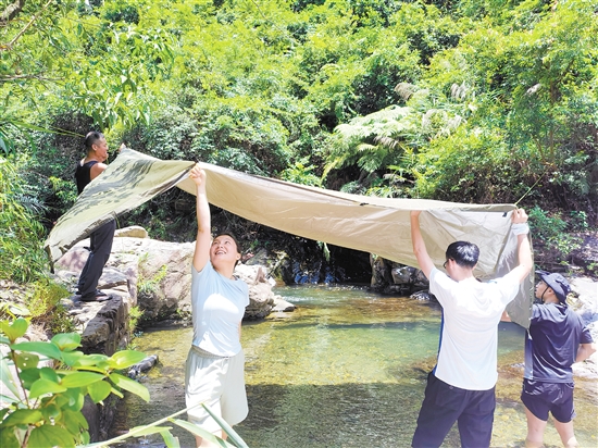 夏季，市民在戶外露營時搭棚防曬。