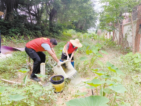 工作人員清理環(huán)境積水。