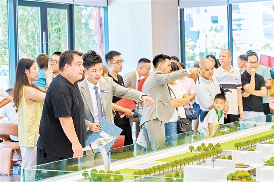 在駿景灣·品悅，銷售人員忙著為客戶介紹樓盤情況。