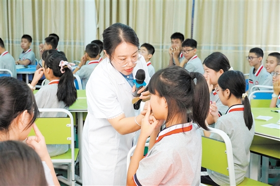 馬玉瑩教學(xué)生找穴位。