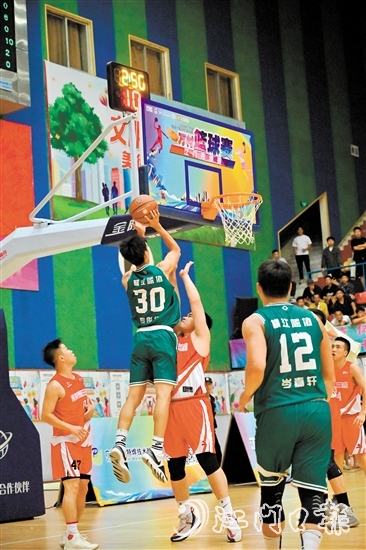 萬村籃球賽江門市級賽決賽現(xiàn)場，橫江村隊隊員迎著防守跳投得分。
