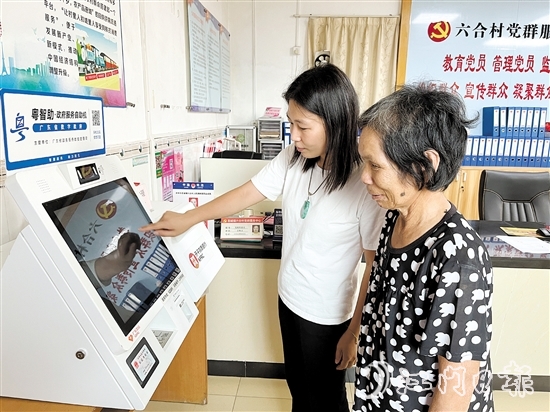 村委會干部在“粵智助”政務(wù)服務(wù)自助機上引導(dǎo)村民辦理社保業(yè)務(wù)。
