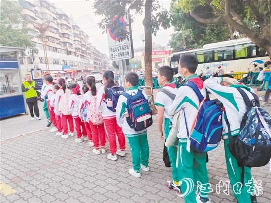 新會(huì)圭峰小學(xué)的學(xué)生有序排隊(duì)，準(zhǔn)備搭乘校園定制公交專(zhuān)線。