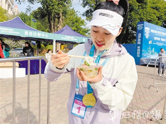 恩平溫泉半程馬拉松女子組冠軍郭利亞品嘗恩平瀨粉并點(diǎn)贊。