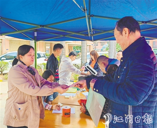 業(yè)委會(huì)工作人員向業(yè)主派發(fā)現(xiàn)金福利。