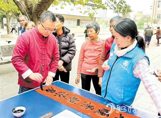 書法家手寫春聯(lián)，為群眾送祝福。