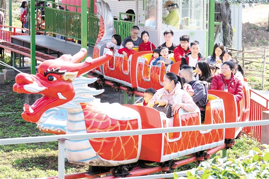 在位于江海區(qū)的江門長廊生態(tài)園，市民游客坐上小火車，享受闔家歡樂時光。