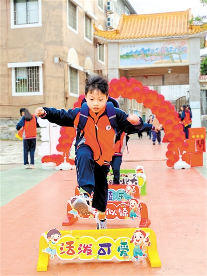 蓬江區(qū)荷塘鎮(zhèn)聯(lián)育小學(xué)學(xué)生跨過吉祥欄。