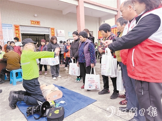 在應急安全知識宣講攤位前，志愿者耐心講解示范急救技能，提升村民的安全意識和自救互救能力。