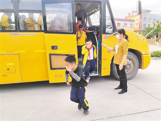 在校車應急疏散演練中，值崗教師組織學生們有序疏散，指導學生們捂住口鼻，快速撤離校車。