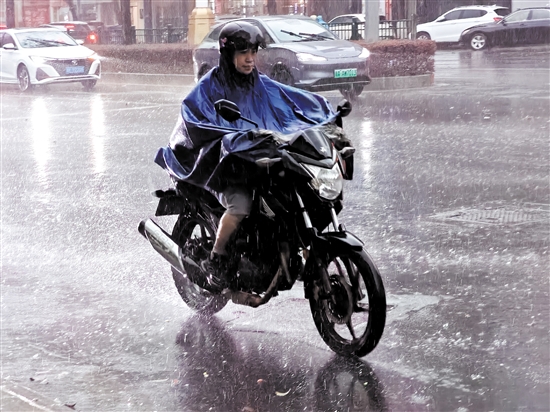 昨天，在市區(qū)東華一路，一位市民騎著摩托車在雨中前行。