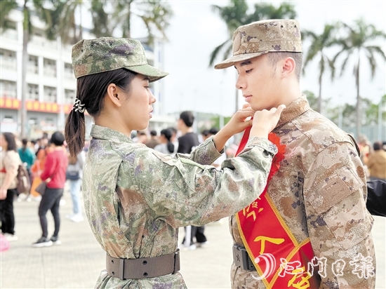 在歡送儀式現(xiàn)場，老兵姐姐為新兵弟弟整理軍裝。