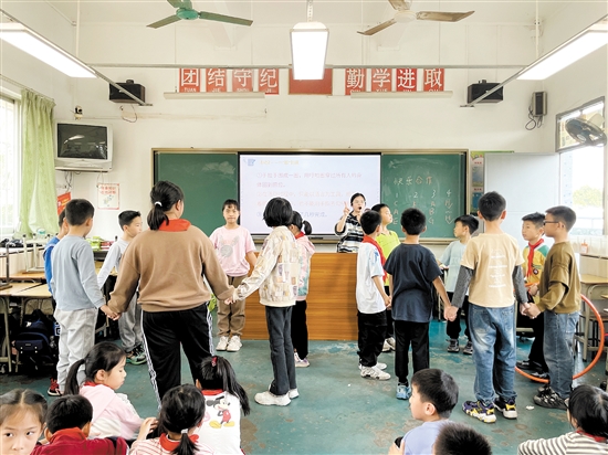 心理課上，鄔緒晴在給學(xué)生講解呼啦圈游戲，讓學(xué)生領(lǐng)會團(tuán)結(jié)協(xié)作精神。