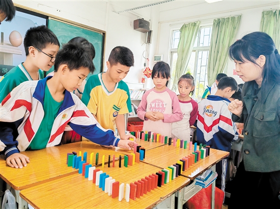 王巧通過多米諾骨牌游戲，和孩子們對話情緒，鼓勵孩子表達(dá)。