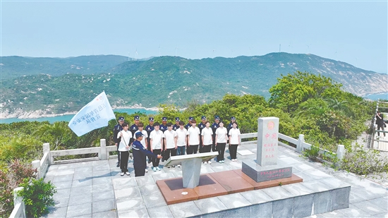 江門市青年學(xué)生國家安全志愿者宣傳隊(duì)成員在江門圍夾島領(lǐng)?；c(diǎn)為領(lǐng)海界碑描紅。