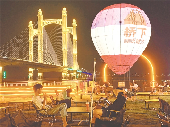 夜幕降臨，潭江兩岸燈火闌珊，市民、游客在“橋下咖啡營(yíng)地”品咖啡、賞夜景，享受愜意時(shí)光。