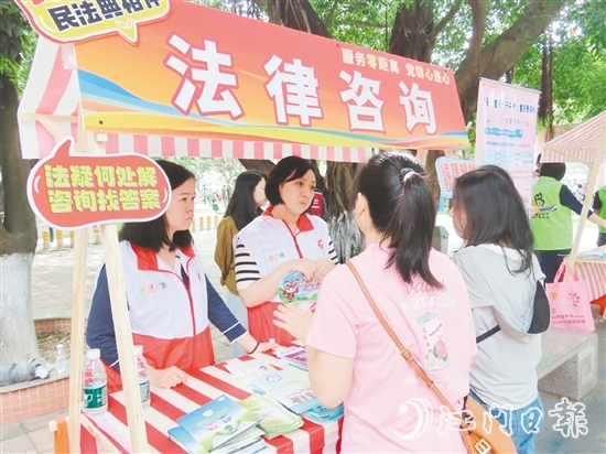 在法律援助攤位，司法系統(tǒng)黨員志愿者耐心解答群眾的法律咨詢。
