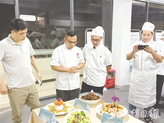 伍立更（左二）對(duì)學(xué)員們的自創(chuàng)菜式一一進(jìn)行點(diǎn)評(píng)和指導(dǎo)。