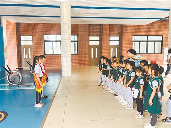 紅領(lǐng)巾講解員帶領(lǐng)孩子參觀校園。