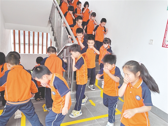 學(xué)生們彎腰低頭、捂住口鼻，按照預(yù)定路線有序撤離。