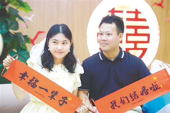 “520”迎來婚姻登記熱潮，在蓬江區(qū)、江海區(qū)的婚姻登記處，新人拍照留念。江門日報記者