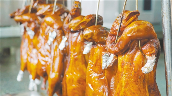 新鮮出爐的燒鵝表皮鮮紅油潤(rùn)，讓人食指大動(dòng)。