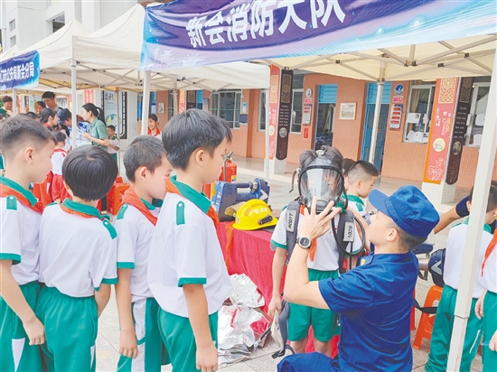 在消防救援大隊的展示區(qū)，同學(xué)們體驗(yàn)了消防員的空氣呼吸器等裝備。