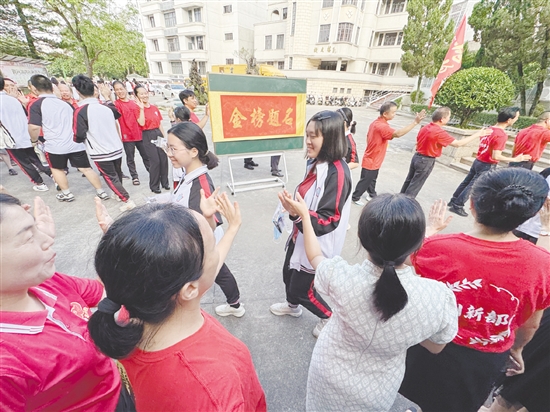 臺(tái)山一中在送考路上設(shè)置了“金榜題名”大字帖，教師身穿紅衣與學(xué)生擊掌，為學(xué)生加油。
