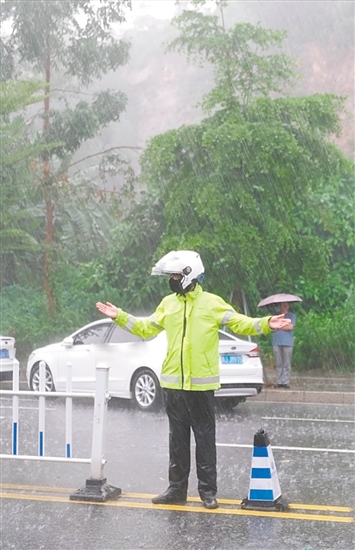 高考期間，交警在大雨中維持交通秩序。