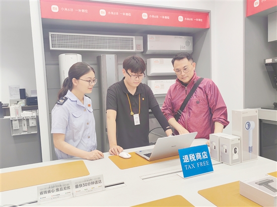 稅務(wù)部門輔導小米之家工作人員為旅客開具退稅申請單。