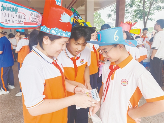 學(xué)生們戴著“數(shù)學(xué)帽”穿梭在各個(gè)游戲攤位間，形成一道亮麗的風(fēng)景線。
