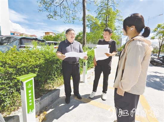 余中宏（左一）與同事一起查看“民生服務充電站”項目建設進度。