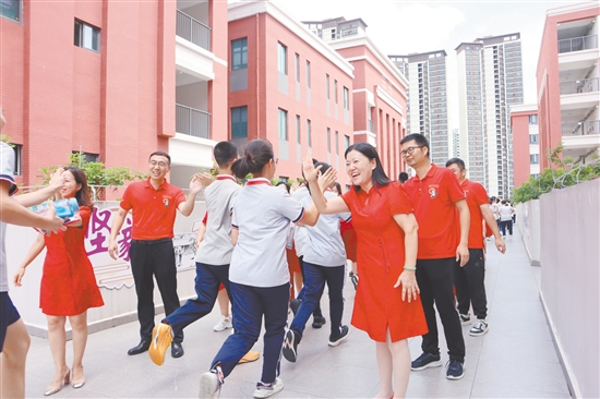 蓬江區(qū)紫茶中學的領導和老師們與考生們擊掌，為他們加油、鼓勁。