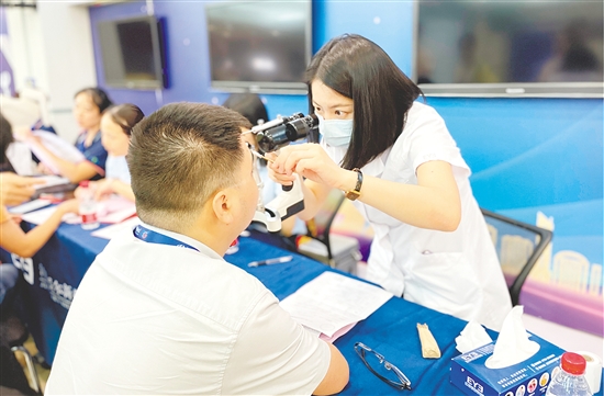 醫(yī)護(hù)人員為企業(yè)職工檢查眼睛。