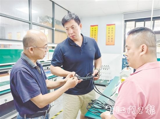 盧慶忠（中）與技術(shù)人員交流產(chǎn)品質(zhì)量問題。