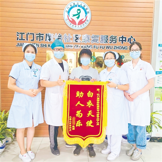 李明給康復(fù)中心醫(yī)護人員送上錦旗。