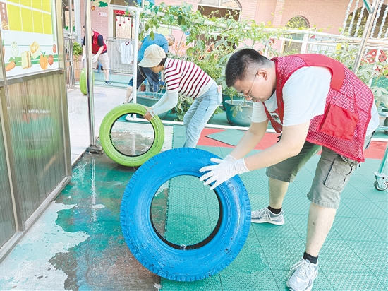 蓬江區(qū)委組織部干部深入幼兒園清理輪胎內(nèi)積水，做好基孔肯雅熱疫情防控工作。