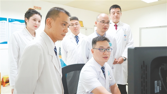 謝志駿（左四）和同事討論影像報(bào)告。