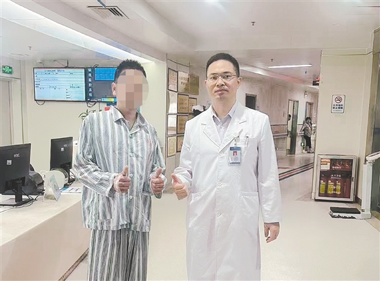 患者和醫(yī)生合影，豎起大拇指表示肯定。