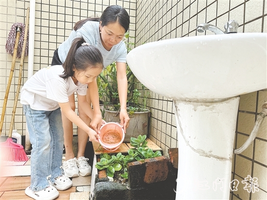 學(xué)生和家長(zhǎng)一起清理家中積水。