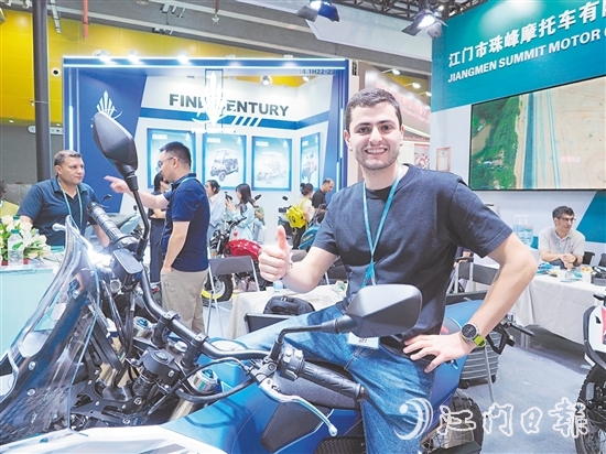在江門市珠峰摩托車有限公司展位，外國客商前來了解摩托車新品情況，并為產(chǎn)品點贊。張澤彬