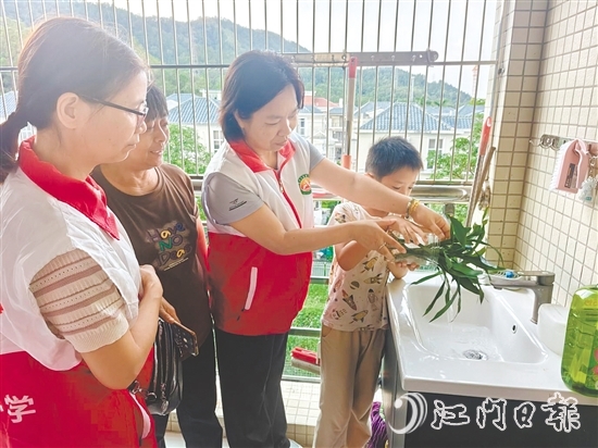 恩平市鰲峰小學(xué)黨員教師入戶指導(dǎo)學(xué)生清積水。