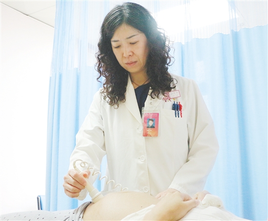 產(chǎn)科醫(yī)生為孕婦檢查胎兒狀況。