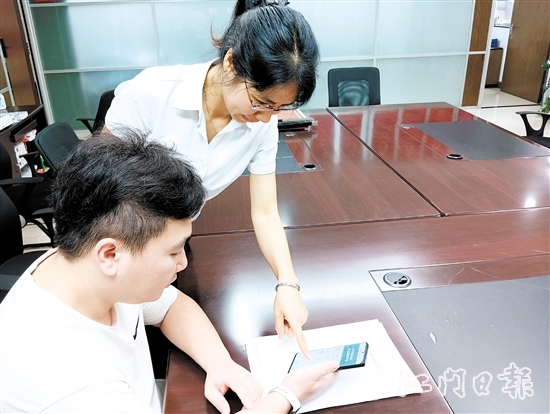 工作人員在指導(dǎo)市民線上交存住宅專項(xiàng)維修資金。陸沿任